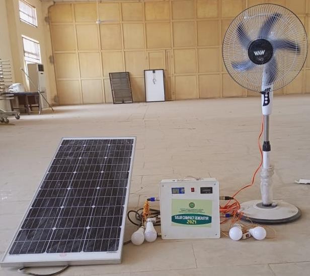 The SERC Solar Compact Generator powering a standing fan and lighting.